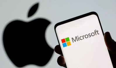 Microsoft logo is seen on the smartphone in front of displayed Apple logo